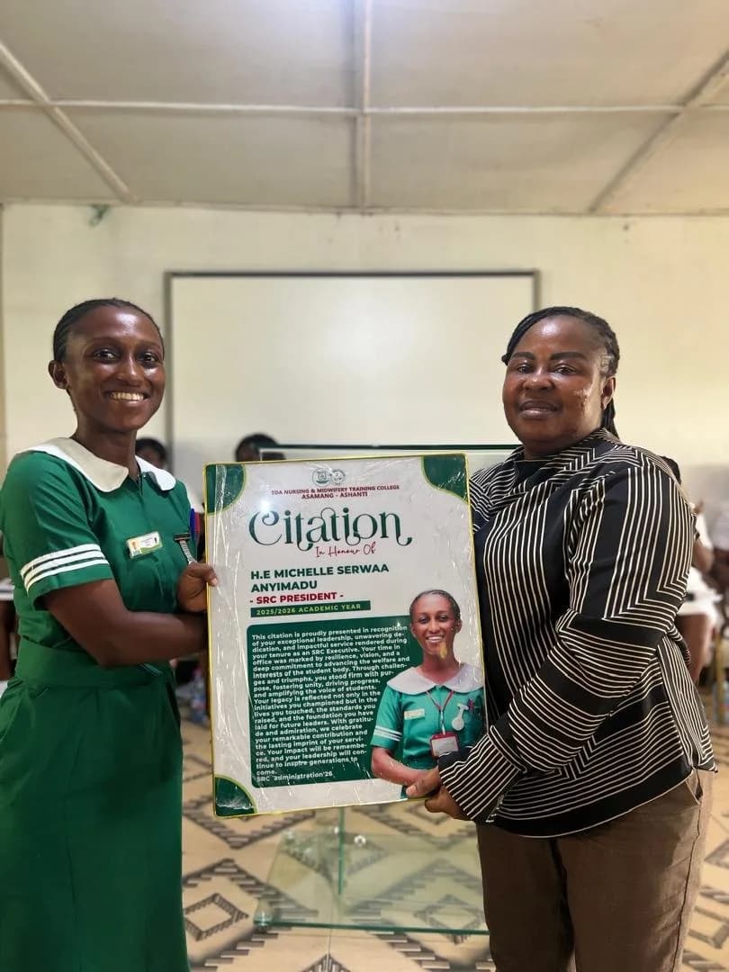 Female student in green nursing uniform presenting citation award to woman in white striped dress during handover ceremony