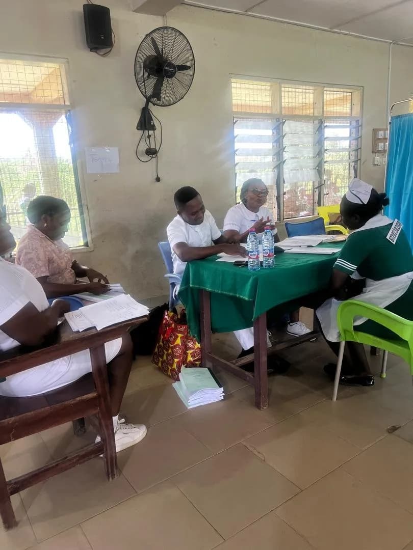 Team 4 examiners engaging a final year student in a viva discussion at a green-draped table