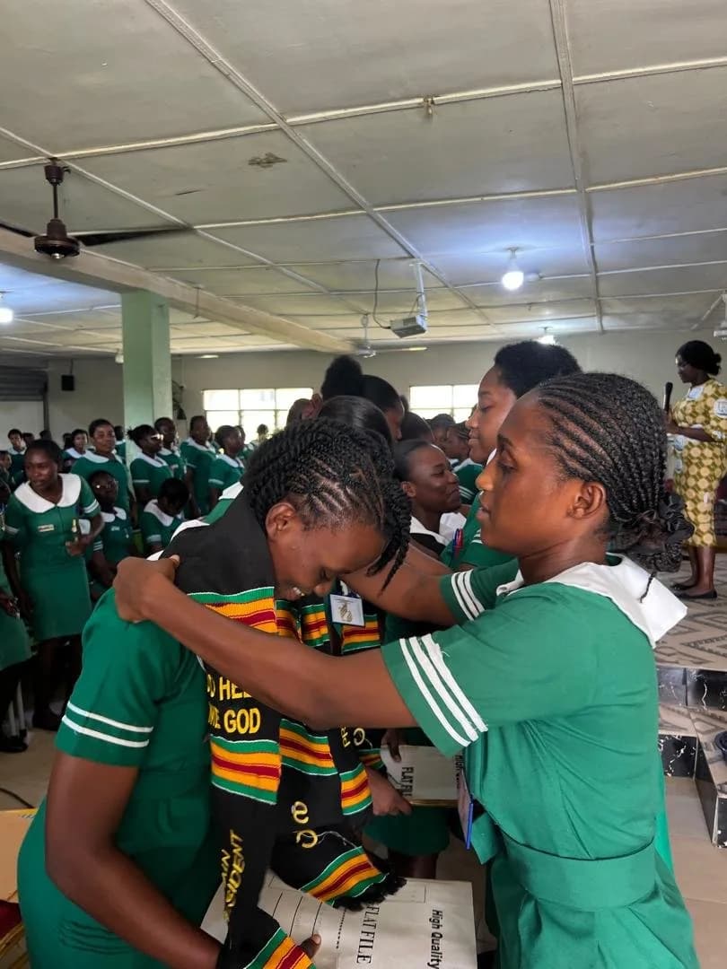 Female student in green nursing uniform smiling during SRC handover ceremony