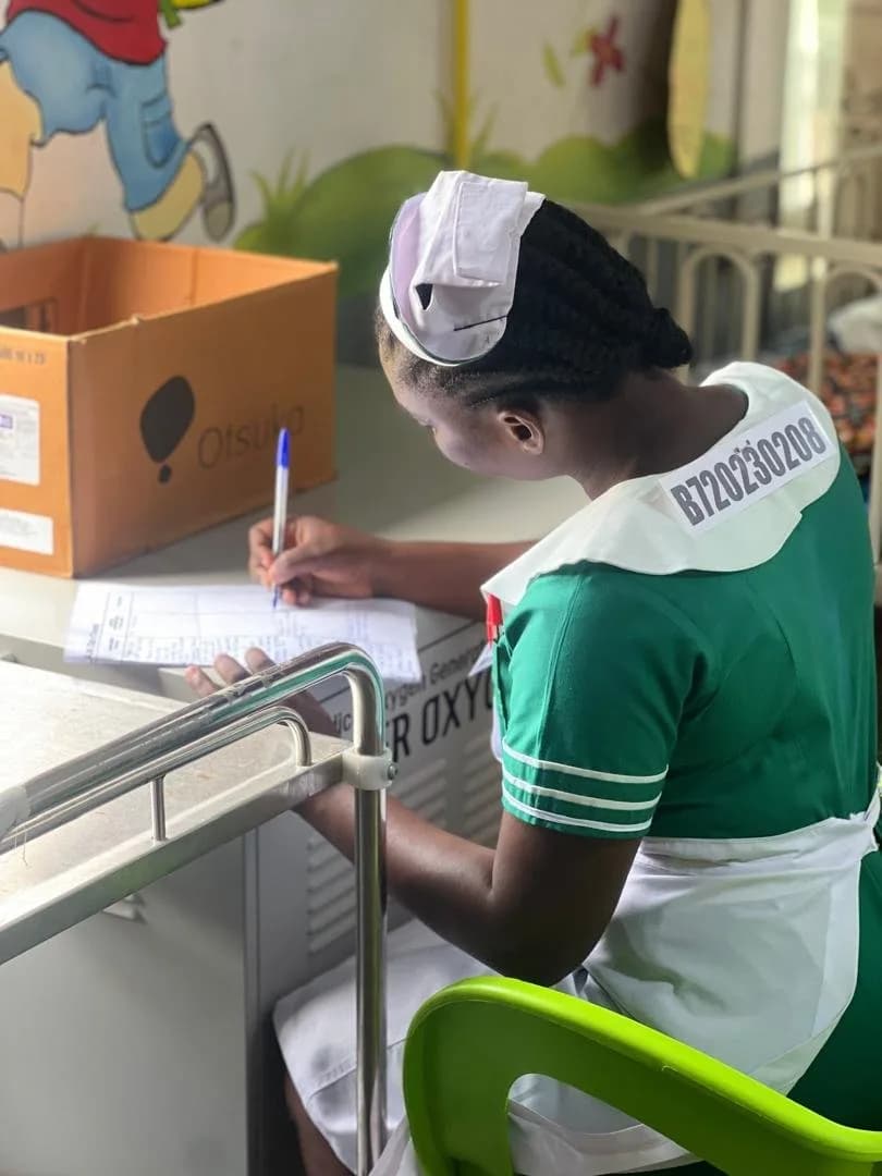 Student nurse charting medication and treatment records at the nurses station