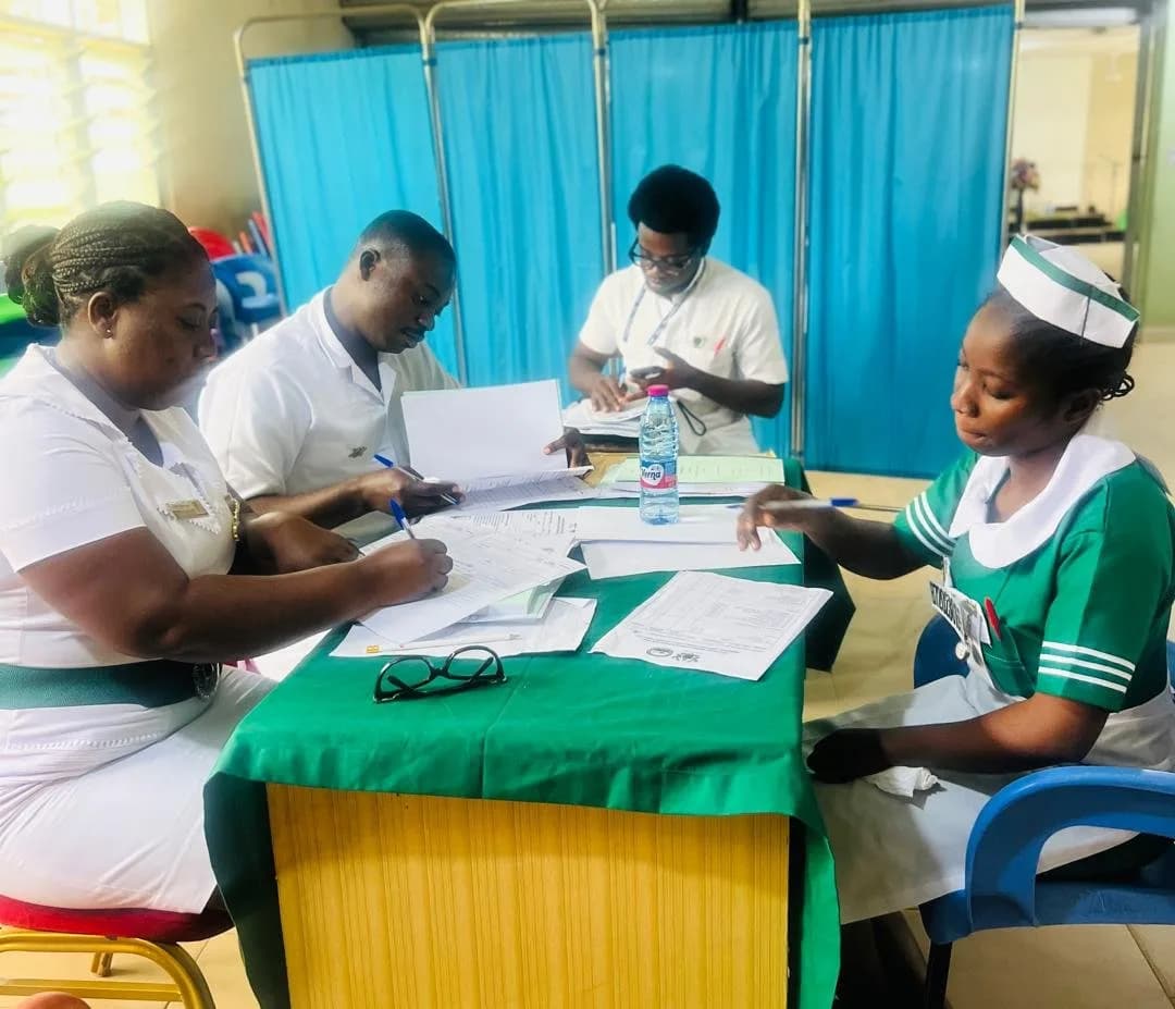 Panel of examiners questioning a final year nursing student across a green-draped table during a viva session