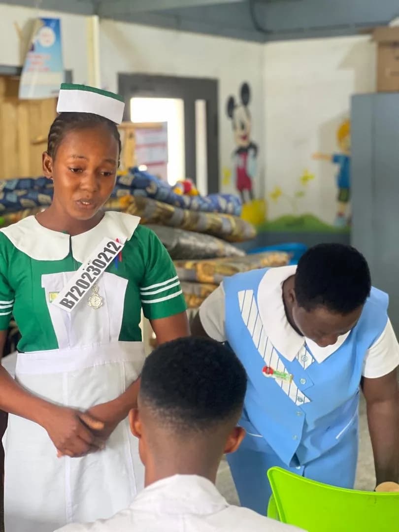 Student nurse interviewing a patient under the observation of a clinical examiner